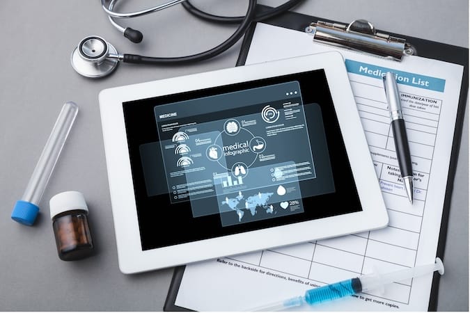 digital tablet with stethoscope wooden table